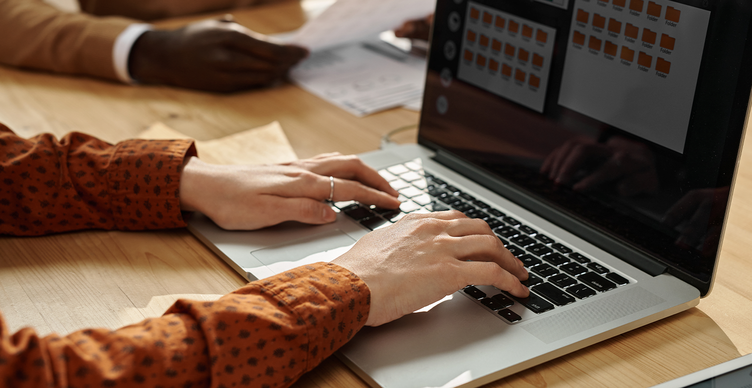 Compliance analysts reviewing data and charts on screens at a desk